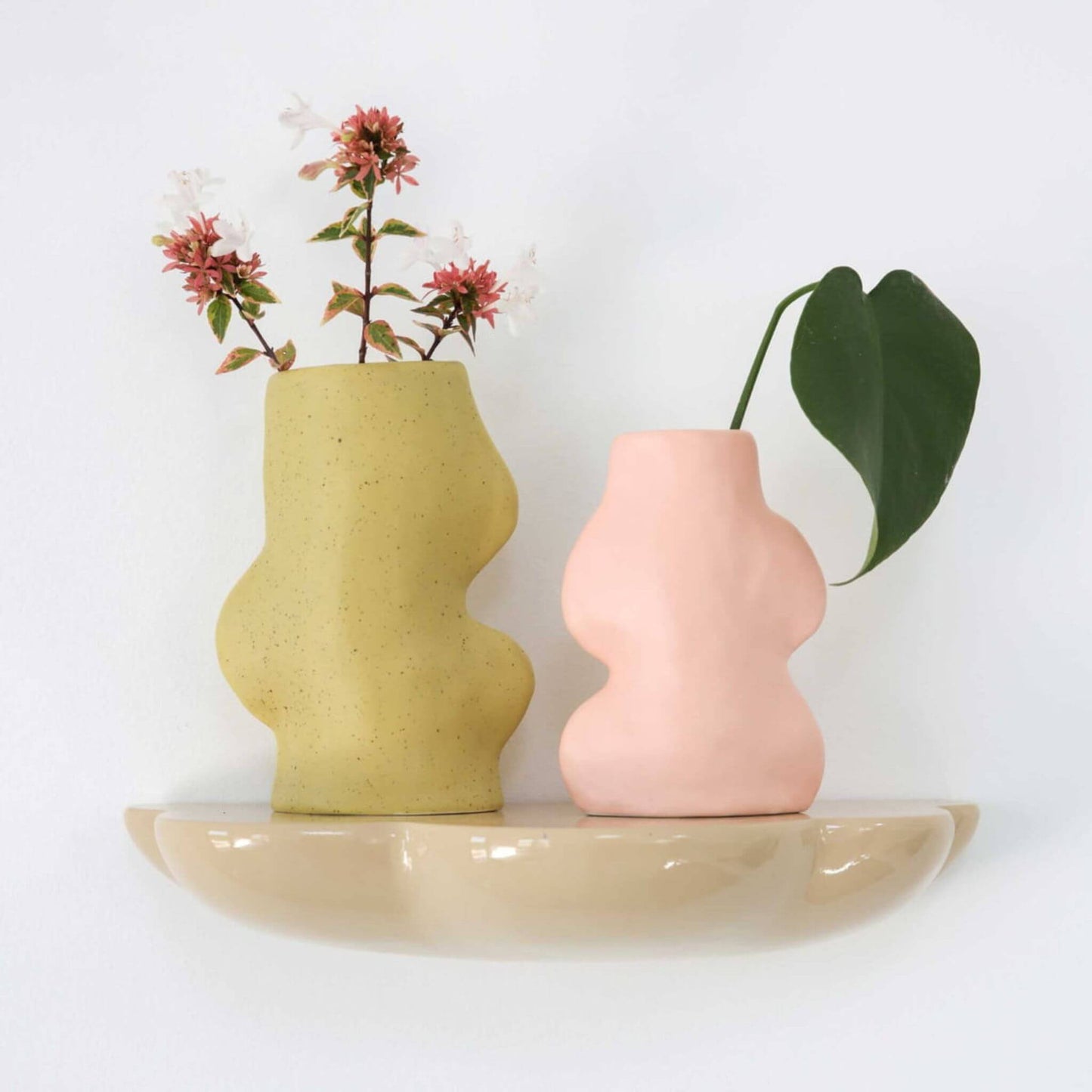Zwei Vasen, grün und rosa, auf Wandboard
