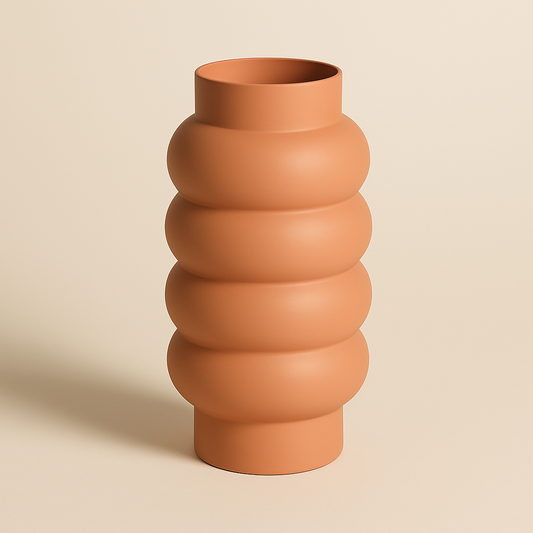 Korallenfarbene Vase in gewelltem Design auf hellem Hintergrund.