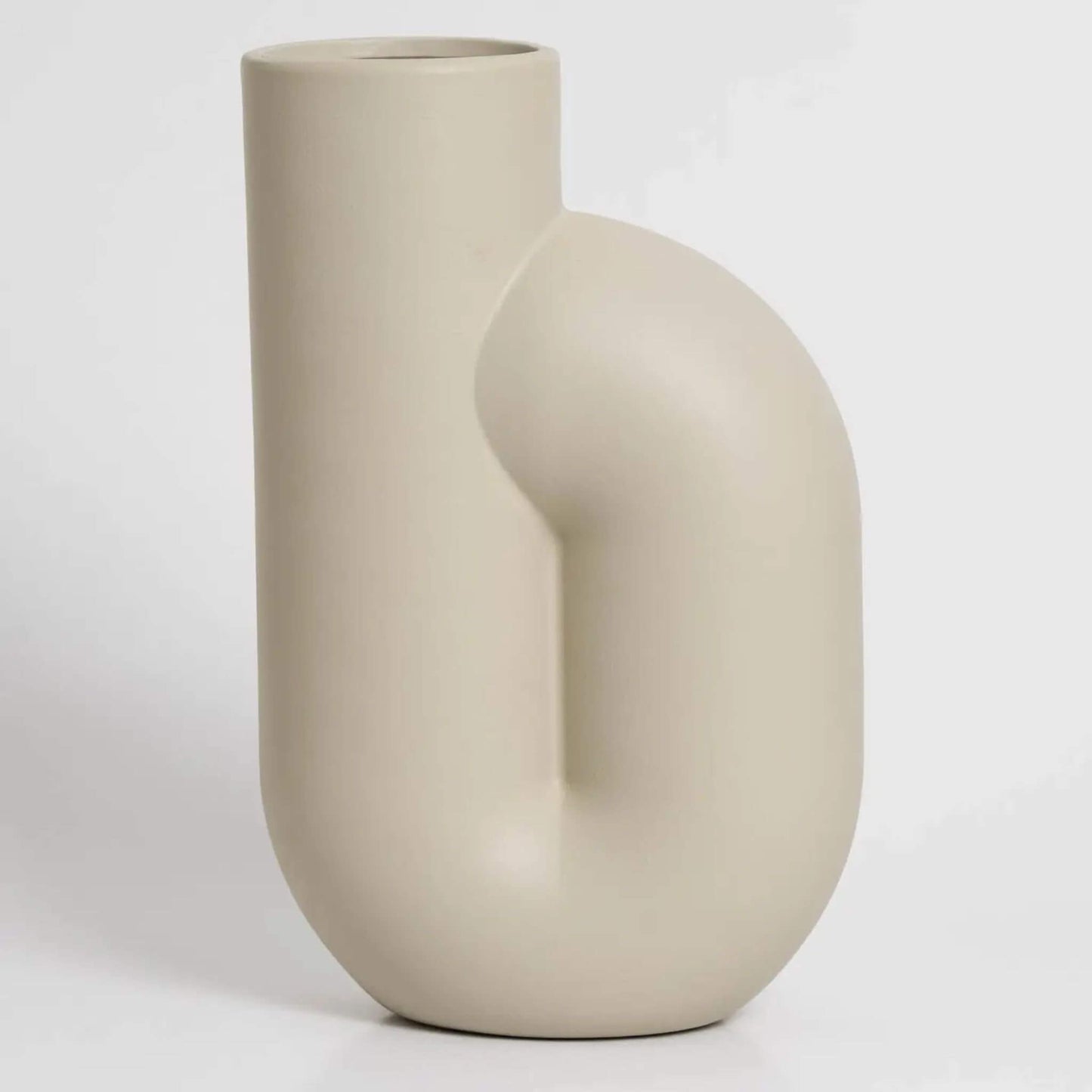 Cremefarbene Vase mit gebogener Form auf hellem Hintergrund.