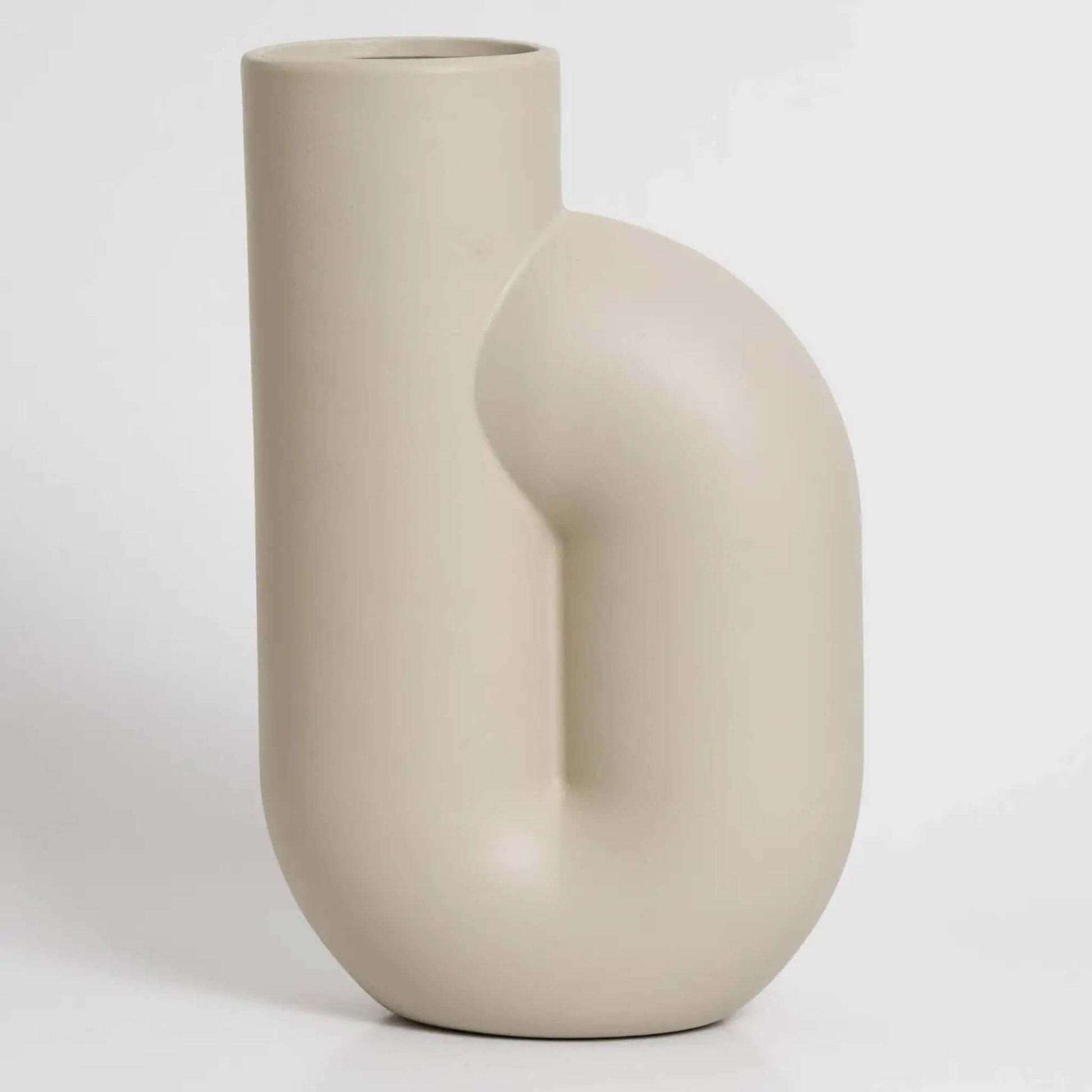 Cremefarbene Vase mit gebogener Form auf hellem Hintergrund.