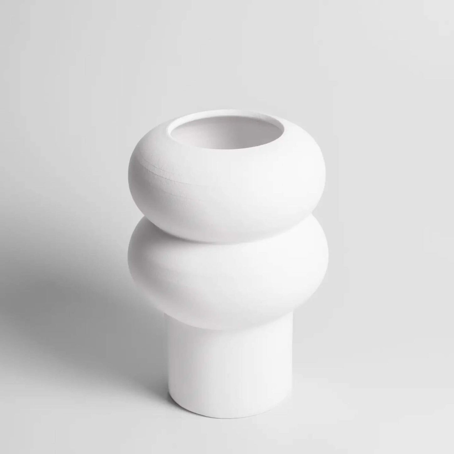 Große, weiße Vase mit markanter runder Wellenform.