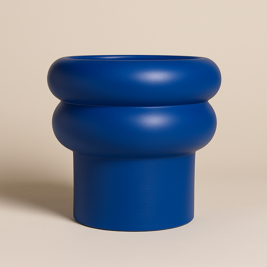Großer, blauer Blumentopf mit runder Wellenform auf hellem Hintergrund.