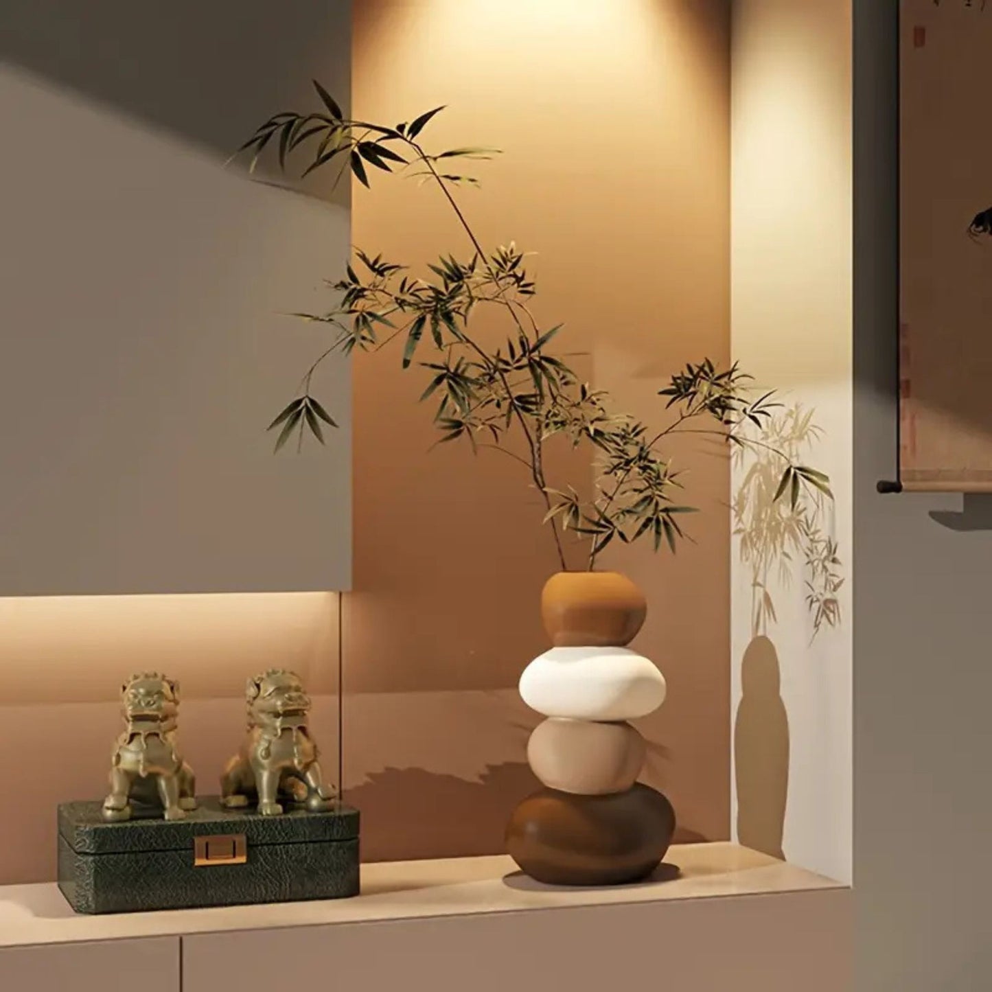 Dekorative Harzvase in Steinoptik mit grünem Bambus, arrangiert auf einem Sideboard neben asiatischen Drachenfiguren.