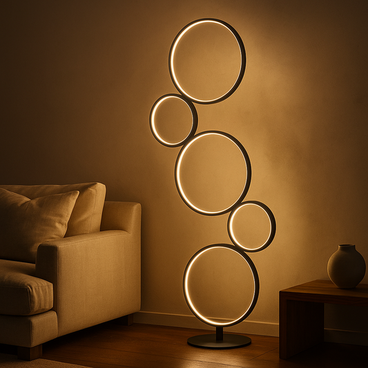 Moderne LED-Stehleuchte mit fünf leuchtenden Ringen, die ein warmes Licht in einem stilvoll eingerichteten Wohnzimmer neben Sofa und Beistelltisch verbreitet.