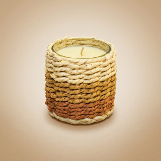 Aulica Duftkerze Moschus kleines Modell, geflochtener Mantel in Creme-Terrakotta-Verlauf mit weißem Wachs und Docht sichtbar, auf neutralem beigen Hintergrund