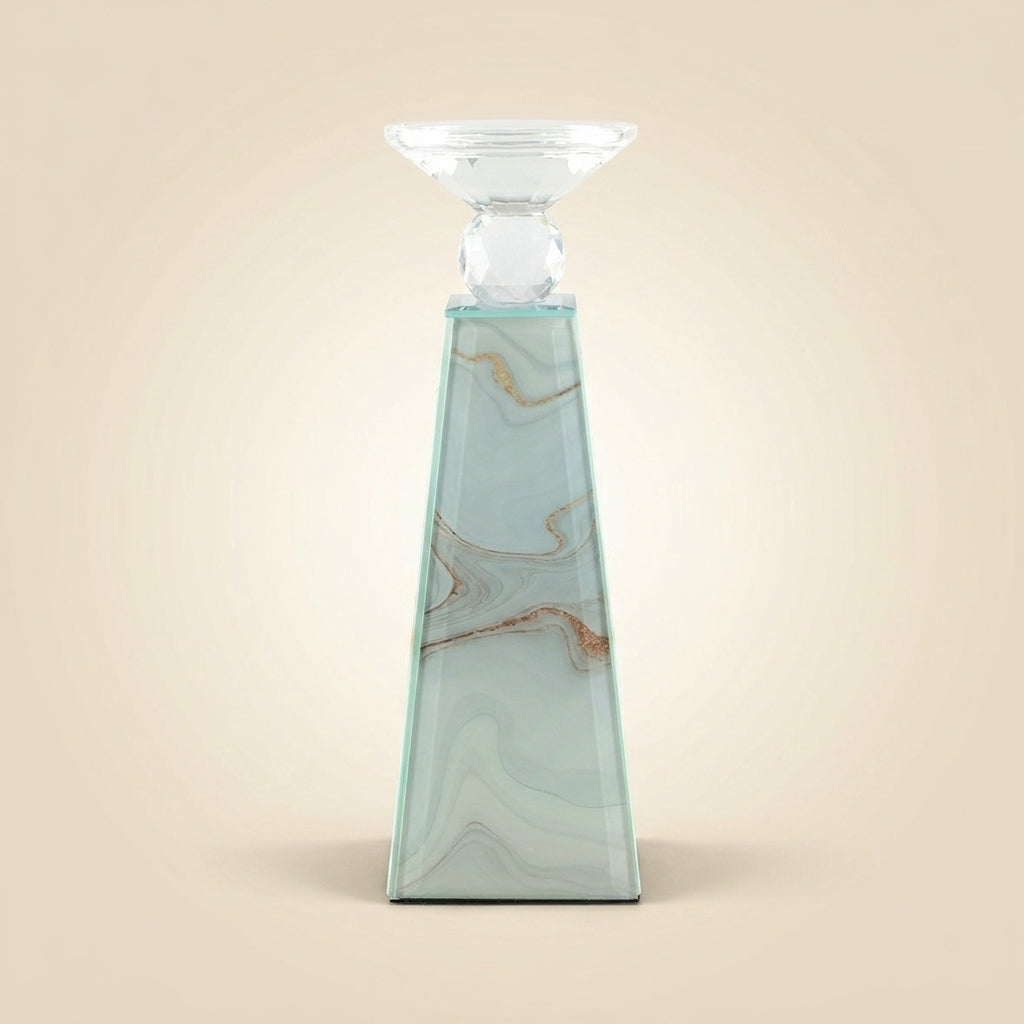 Eleganter Kerzenhalter in Pyramidenform mit Marmoroptik mit goldenen Akzenten, kristallklarem Facettenaufsatz und geschwungenem Teelichtschälchen aus Glas, freigestellt vor beigem Hintergrund.