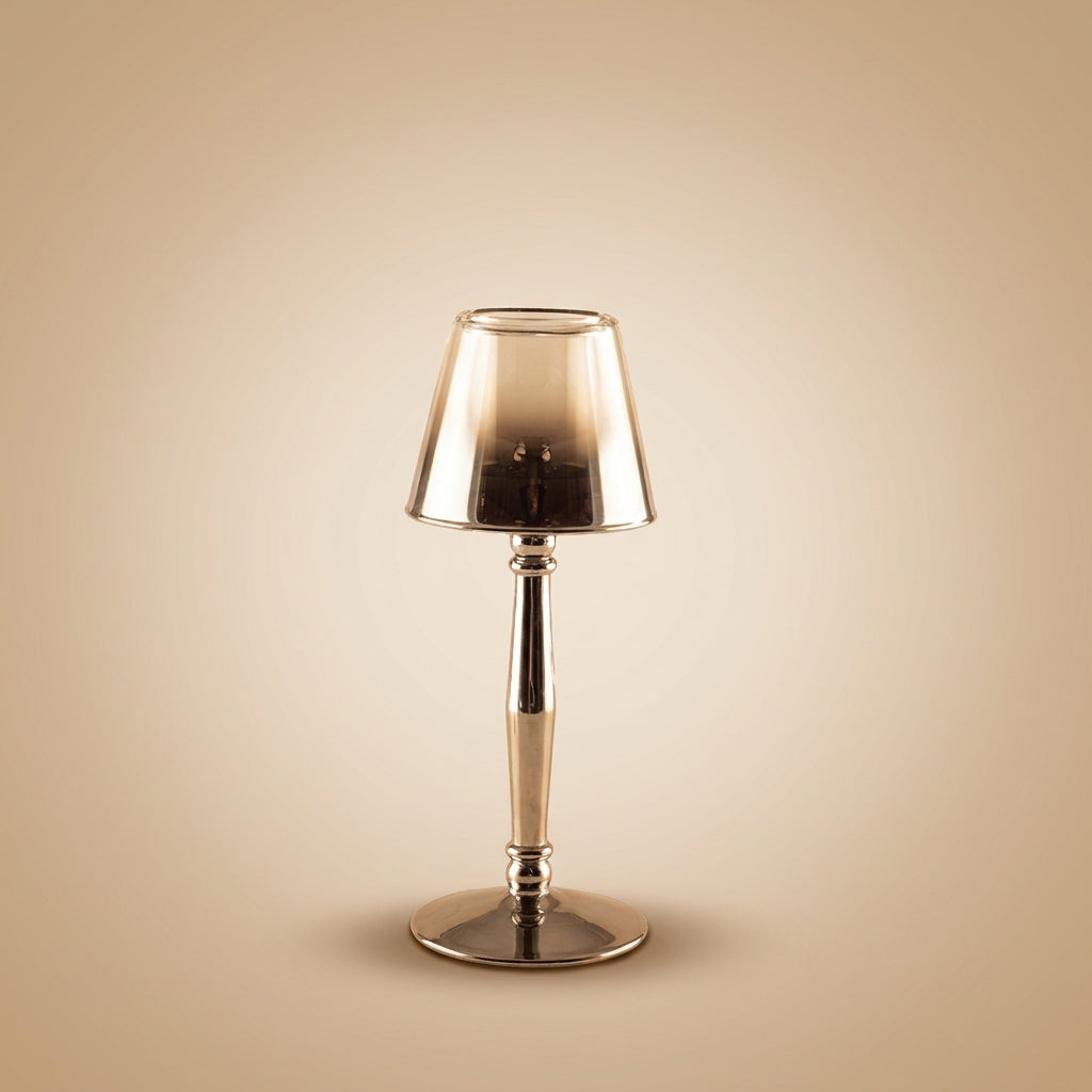 Aulica Kerzenhalter Lampenform Silber, polierter Metallschaft mit ausgestelltem Standfuß und irisierendem Rauchglas-Schirm, auf neutralem beigen Hintergrund