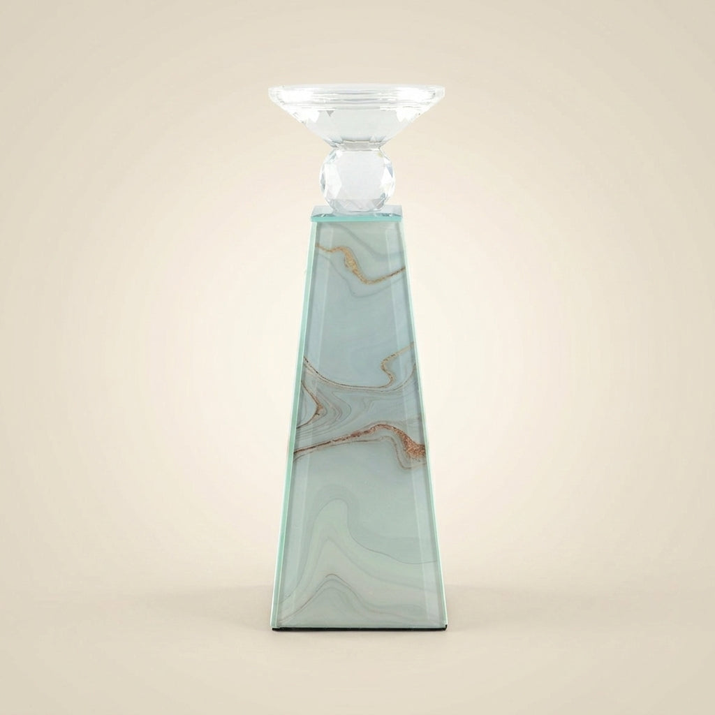 Eleganter Kerzenhalter in Pyramidenform mit Marmoroptik mit goldenen Akzenten, kristallklarem Facettenaufsatz und geschwungenem Teelichtschälchen aus Glas, freigestellt vor beigem Hintergrund.