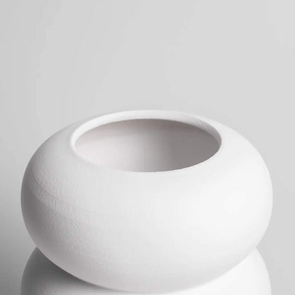 Detailansicht der weißen Vase mit runder Öffnung und geschwungener Form.