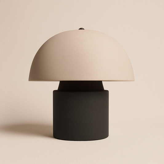 Schwarz-weiße Pilzlampe mit rundem Schirm und zylindrischem Sockel vor weißem Hintergrund.