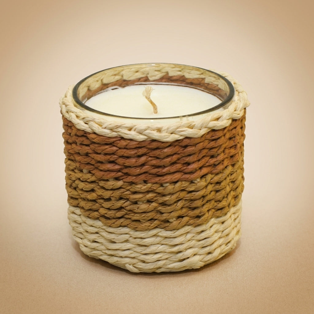 Aulica Duftkerze Moschus großes Modell 10x10x10cm, geflochtener Naturfasermantel in Creme-Terrakotta-Verlauf mit weißem Wachs und Docht, Freisteller auf beigem Hintergrund