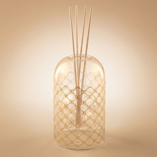 Aulica Raumdiffusor Moschus Gold 8,5x14cm, kuppelförmige Glasflasche mit goldenem Wabenmuster und weißen Reedstäbchen, Freisteller auf beigem Hintergrund