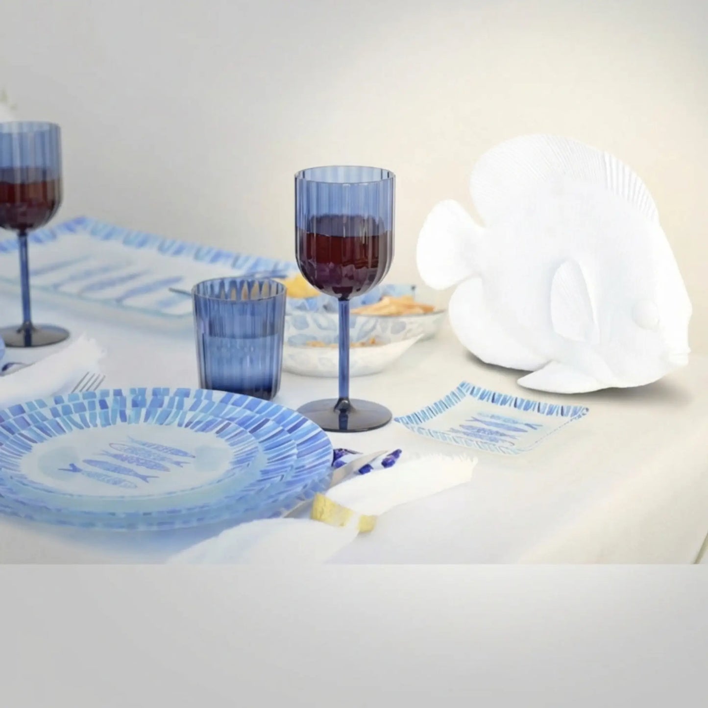 Weißer dekorativer Fisch aus Polyresin auf gedecktem Tisch