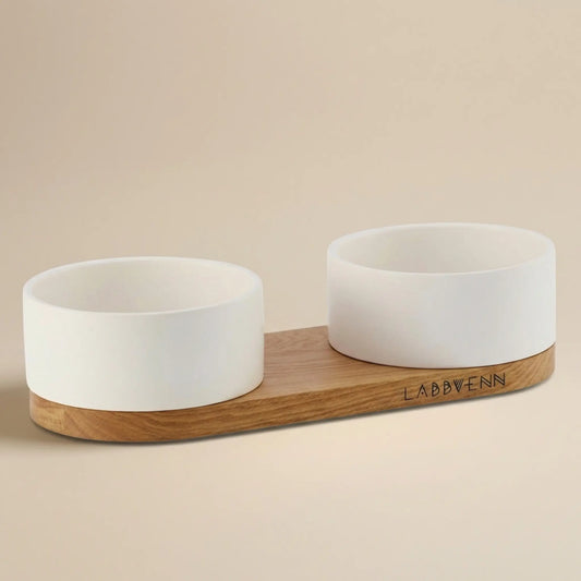 Weiße Keramik Futternäpfe Vuku auf schlichter Holzhalterung in neutraler Studioaufnahme