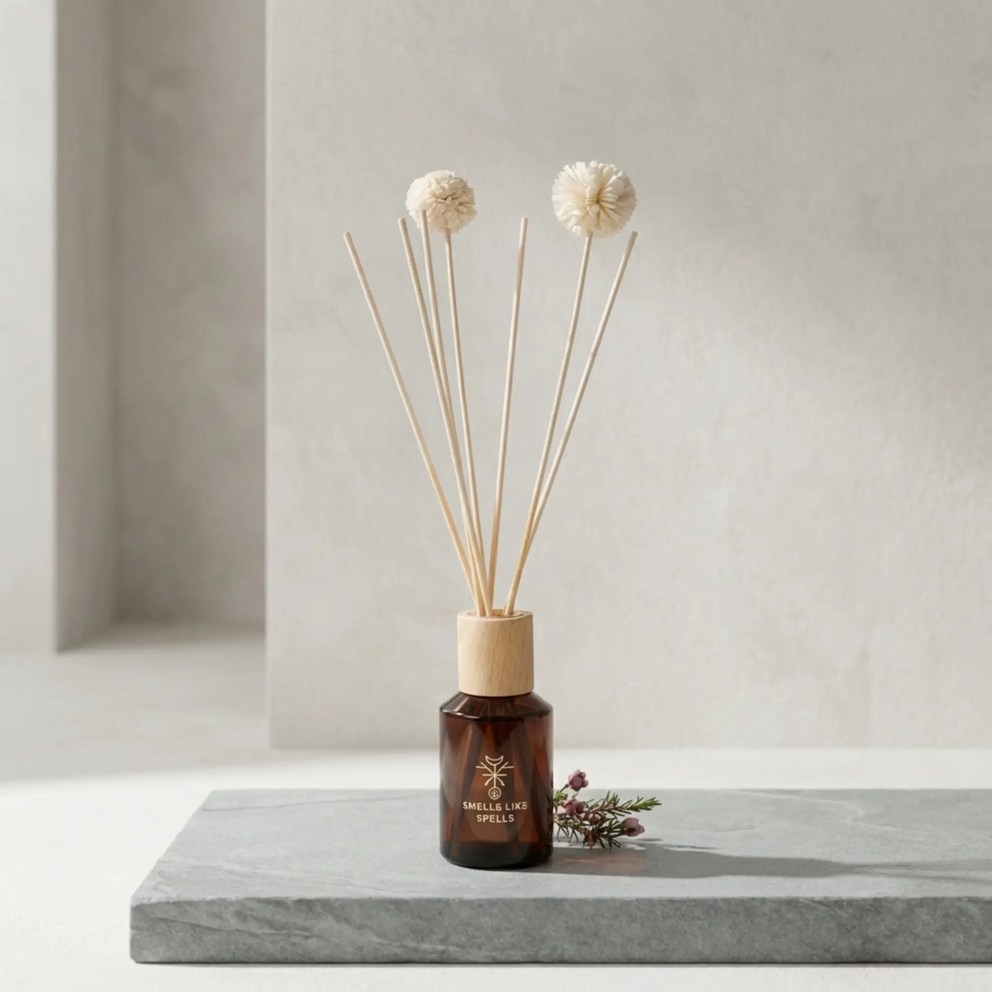Raumparfum ODIN mit Holzstäbchen auf grauer Steinoberfläche im minimalistischen Ambiente