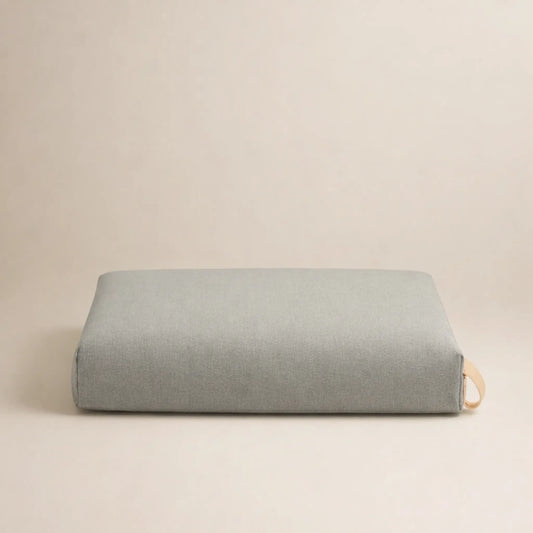 Rechteckiges, hellbeiges Hundekissen in schlichter Form, freigestellt vor neutralem Hintergrund