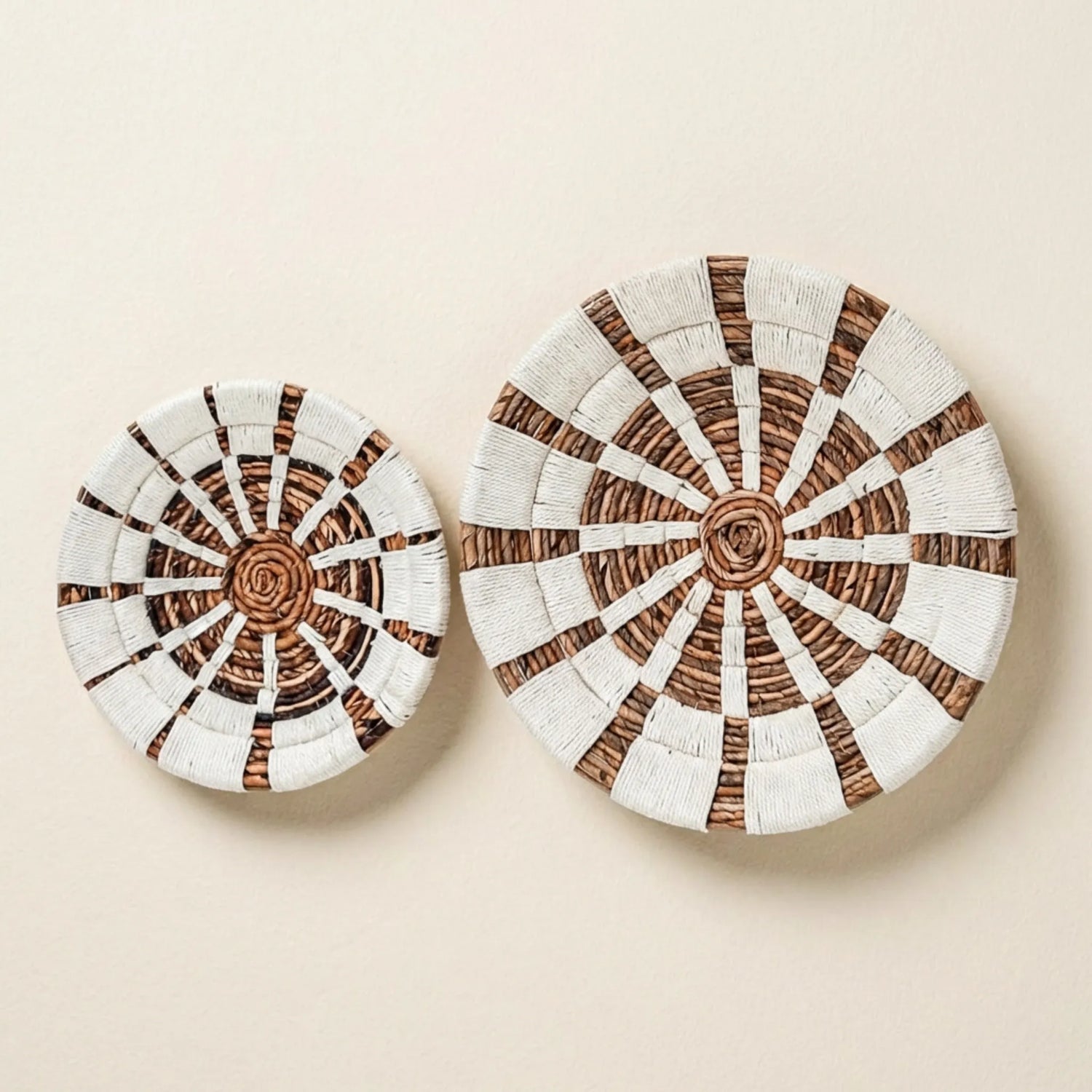 Rundes Wandbild aus Bananenfaser mit weißem Baumwollmuster vor beige Wand
